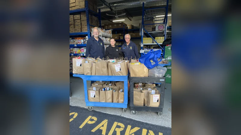 Kat Brazier with Georgetown Bread Basket volunteers and carts of donated grocery bags from her 3rd Annual Thanksgiving Food Drive